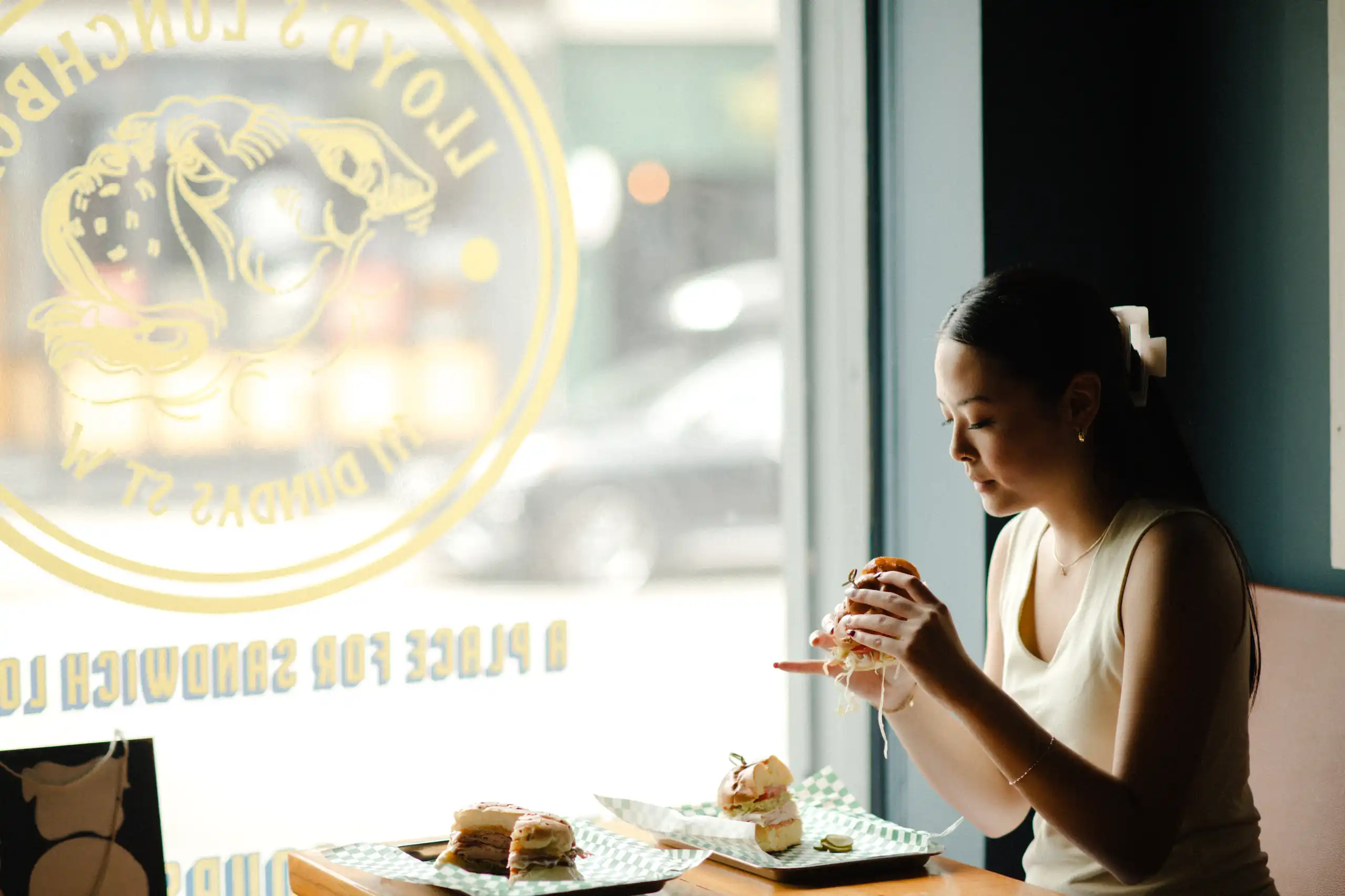 A visitor at a window seat in a downtown Whitby sandwich shop